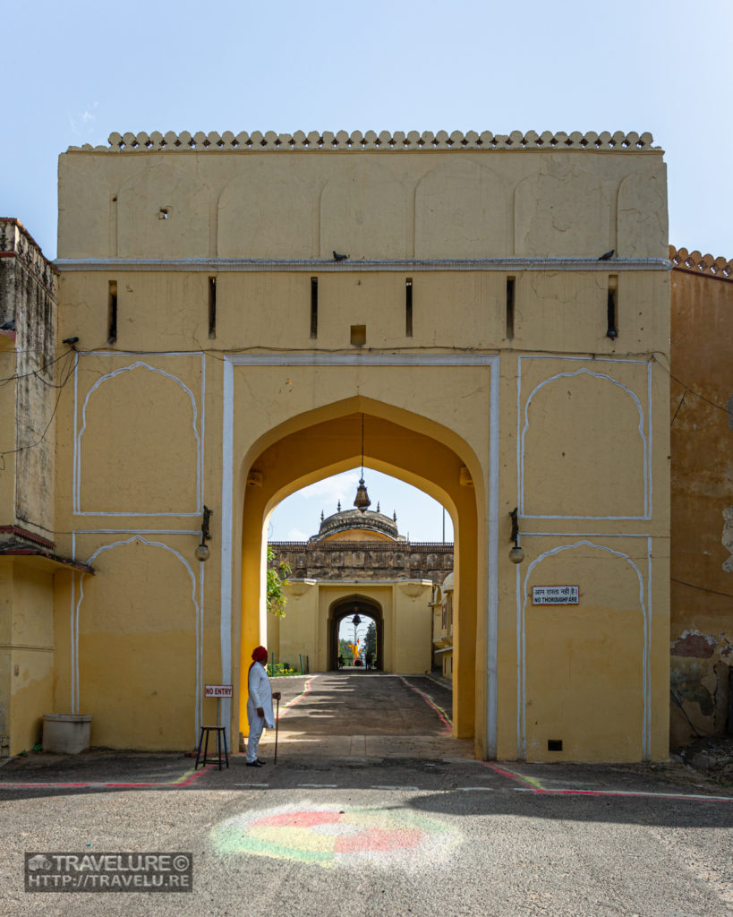 A sentinel in traditional attire stands guard at the primary entrance of the City Palace - Travelure ©.