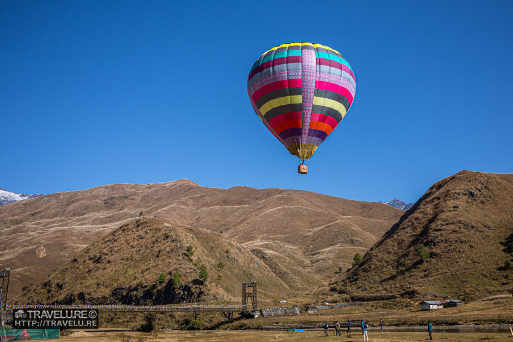 A hot air balloon hovers over the festival grounds. - Travelure ©
