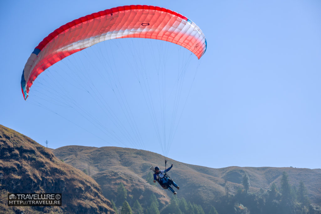 A paraglider attempts a precision landing at a designated spot - Travelure ©