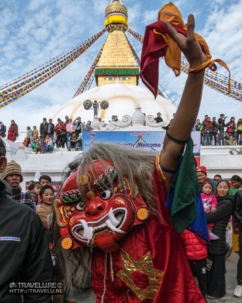 Masked guy enthralling the tourists at the entrance passage to Boudhanath Stupa - Travelure ©