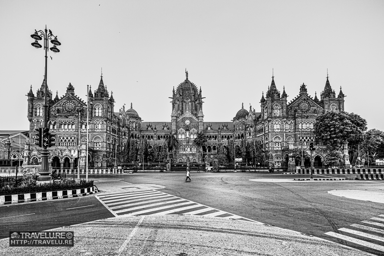 Chhatrapati Shivaji Maharaj Terminus, Mumbai — full Victorian Gothic facade, empty road, single pedestrian, black and white, Covid lockdown 2020, Maharashtra, India.